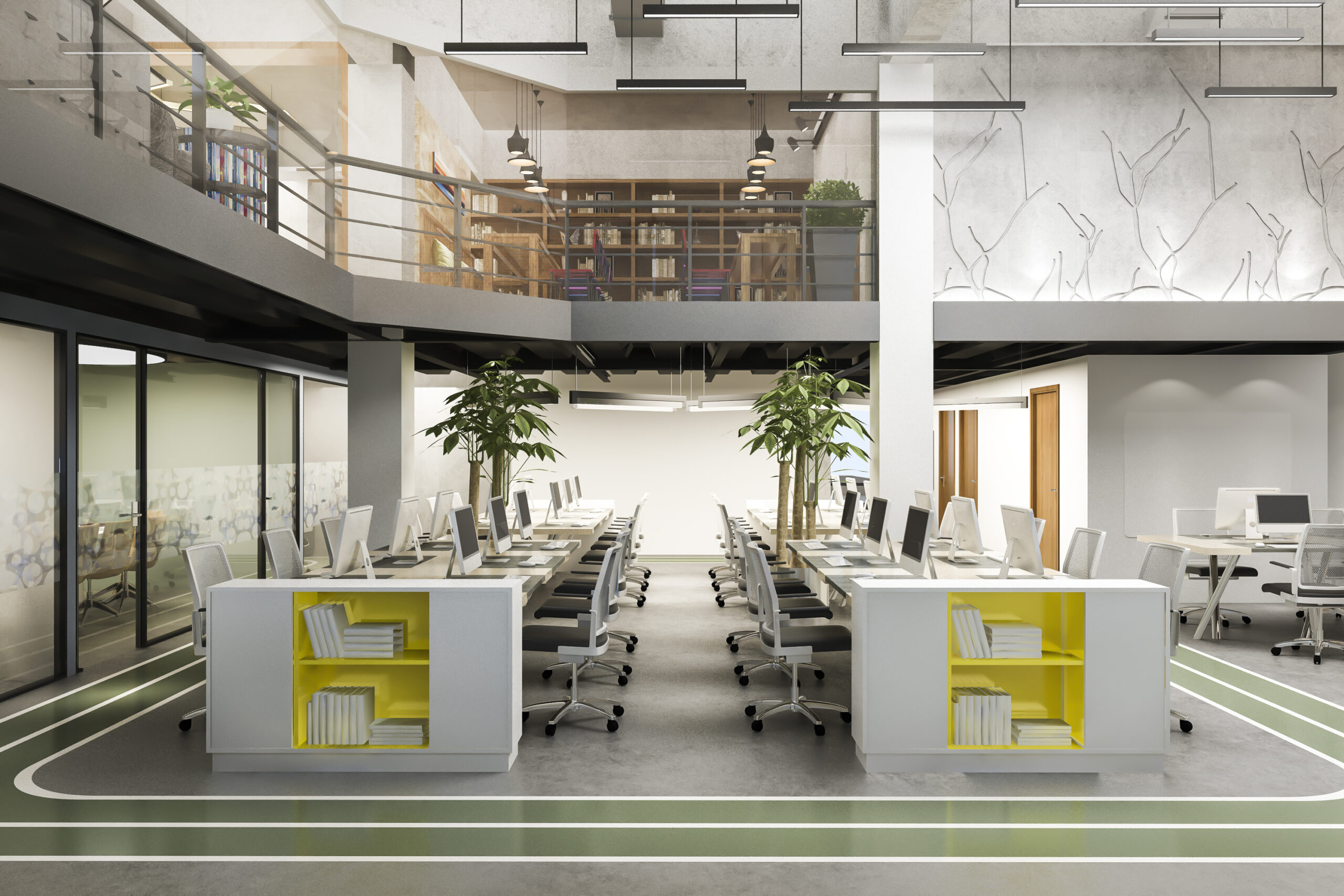 Open-plan office with rows of desks and monitors below a mezzanine library and concrete columns